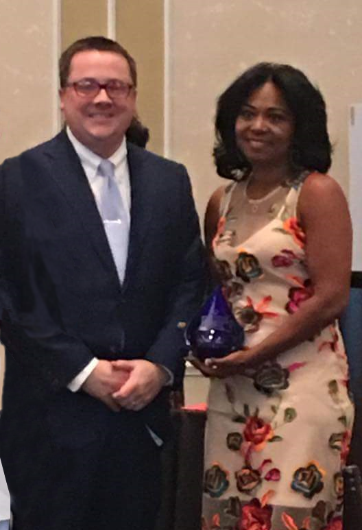 Augusta GA Attorney Adam King, Nicholson Revell LLP presenting Deanna Brown Thomas the Nicholson Revell Woman of the Year Shero Award for 2017.